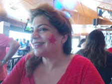 Woman with a painted maple leaf on her cheek